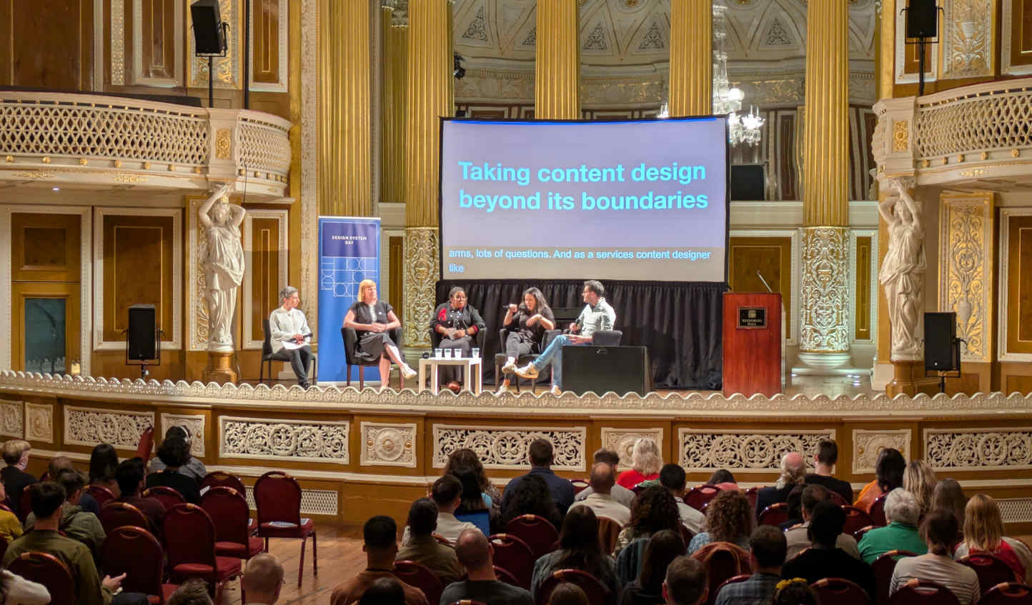 Panel discussion about content design on stage at Design System Day 2024 held in St. George's Hall, Liverpool.